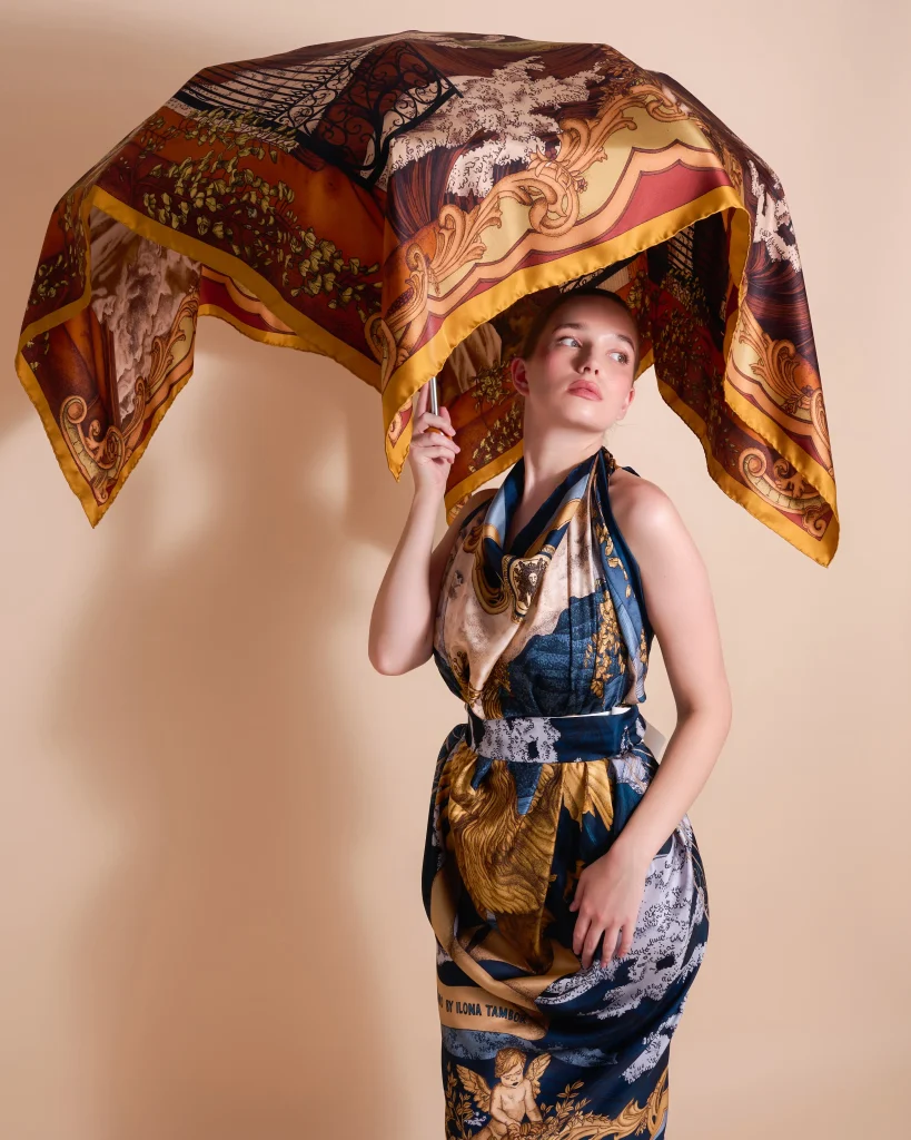 Model holding Ilona Tambor silk scarf Lago di Como in Verdant Gold above head, A/W 2025 collection campaign.