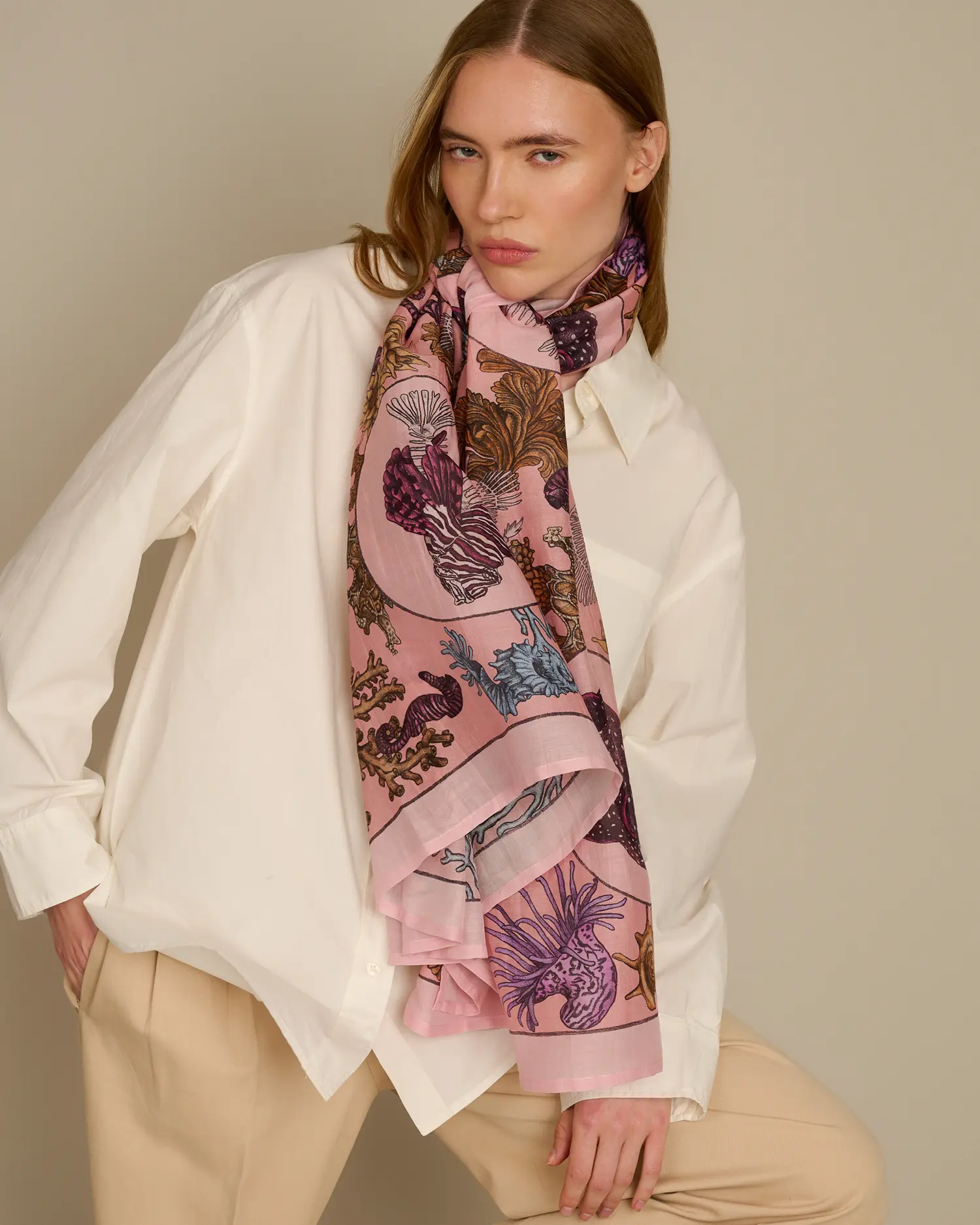 Woman wearing pink cotton silk scarf with sea life inspired design by Ilona Tambor